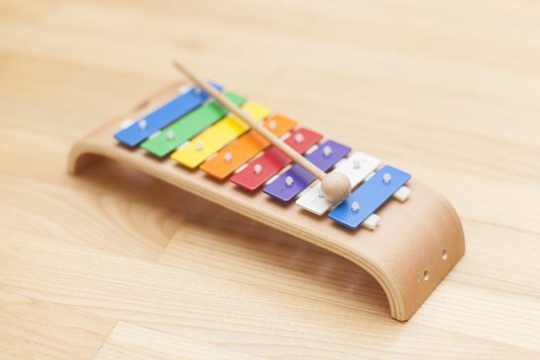 Ein buntes Xylophon mit einem Schläger mit dem Kinder Musik machen können.