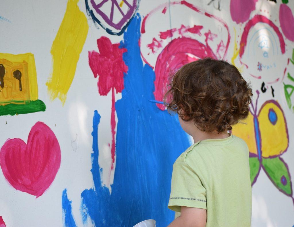Kinder malt auf einer großen Leinwand